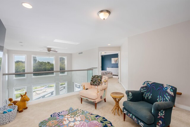 living area featuring carpet, a healthy amount of sunlight, and ceiling fan