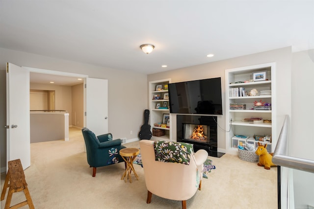 carpeted living room with built in features, a tile fireplace, baseboards, and recessed lighting