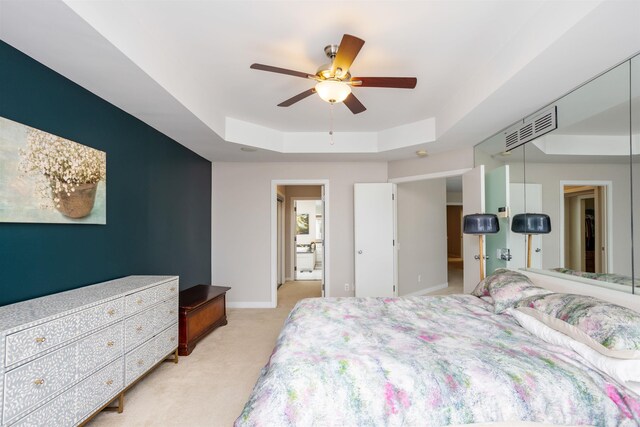 carpeted bedroom featuring ceiling fan and a raised ceiling