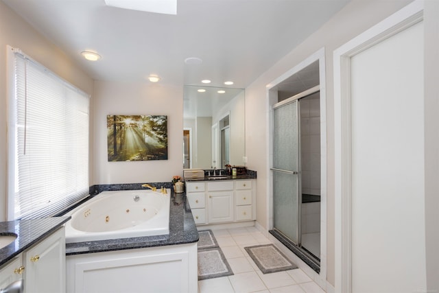 bathroom with tile patterned flooring, plenty of natural light, vanity, and a whirlpool tub