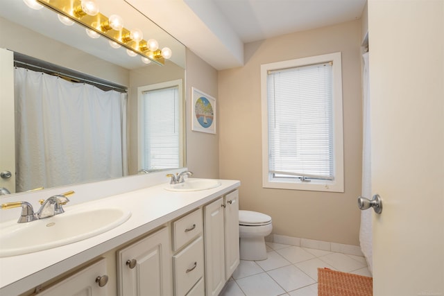 bathroom with double vanity, baseboards, a sink, and tile patterned floors