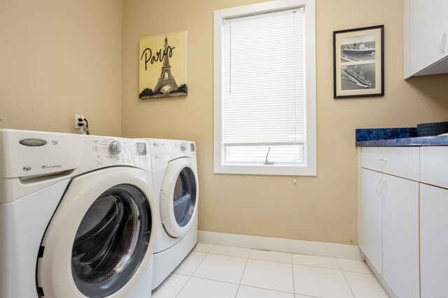 laundry area featuring cabinets, independent washer and dryer, and light tile patterned flooring