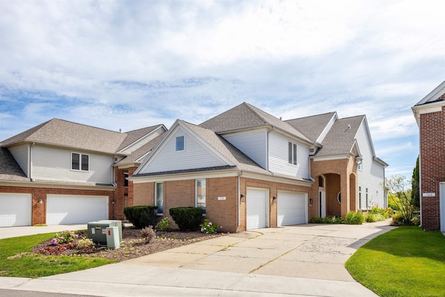 view of front facade with a garage, concrete driveway, brick siding, and roof with shingles