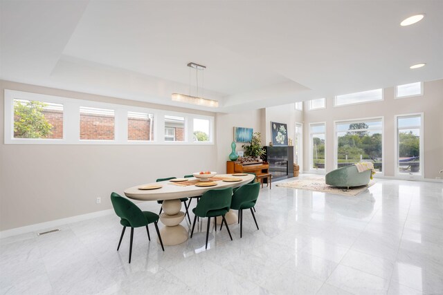 tiled dining space featuring a tray ceiling