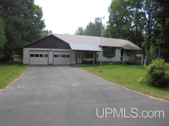 ranch-style house featuring a garage and a front yard