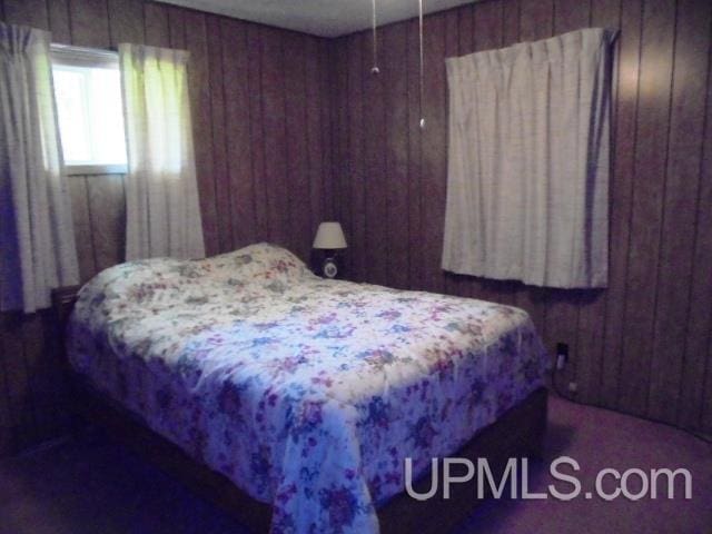 bedroom with wood walls