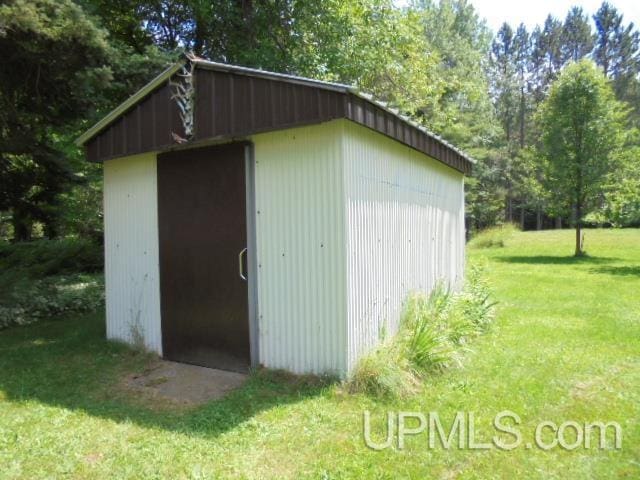 view of outdoor structure featuring a lawn