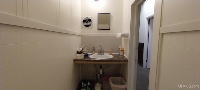 bathroom with vanity and tile walls