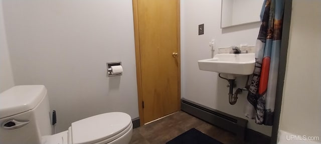 bathroom featuring a baseboard heating unit, sink, and toilet