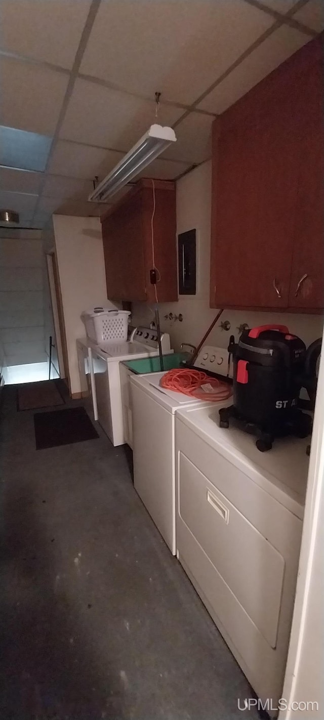 laundry area featuring washing machine and dryer, cabinets, and electric panel