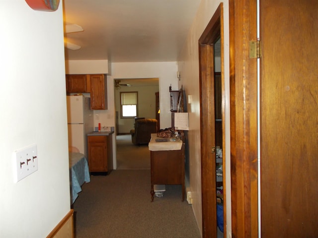 hallway featuring dark carpet