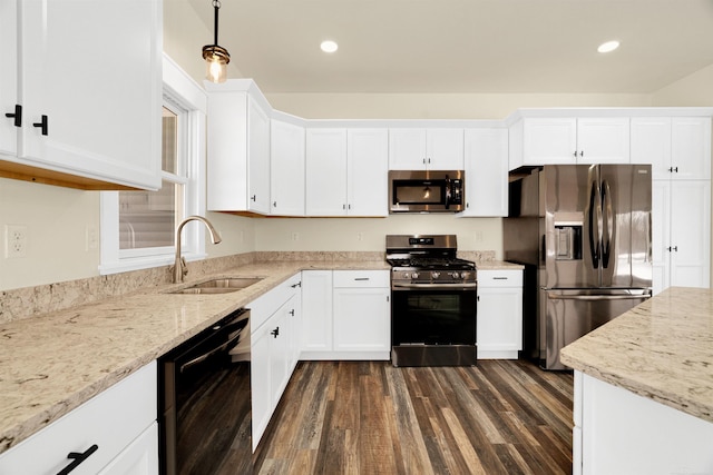 kitchen featuring sink, dark wood-type flooring, stainless steel appliances, light stone counters, and white cabinets