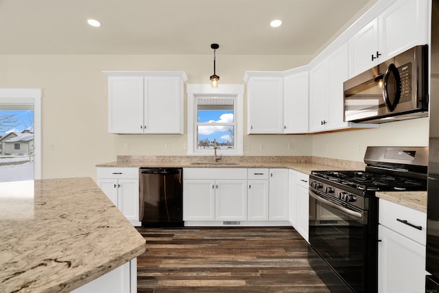 kitchen with white cabinets, decorative light fixtures, sink, and black appliances