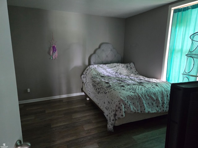 bedroom with dark hardwood / wood-style floors