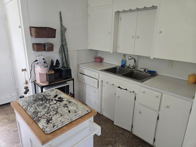 kitchen with white cabinets, sink, and a baseboard radiator