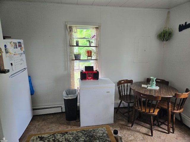 dining space with a baseboard heating unit and electric panel