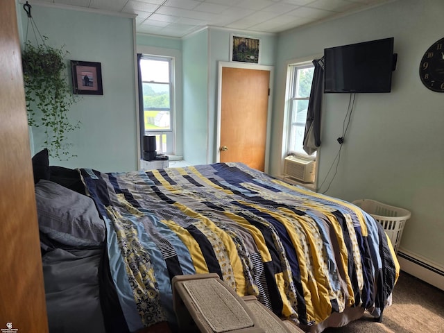 carpeted bedroom with cooling unit and a baseboard heating unit