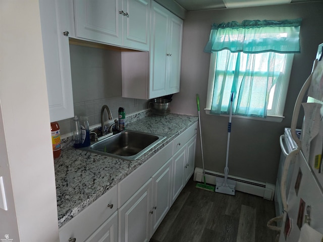 kitchen with sink, white cabinetry, baseboard heating, dark hardwood / wood-style flooring, and light stone counters