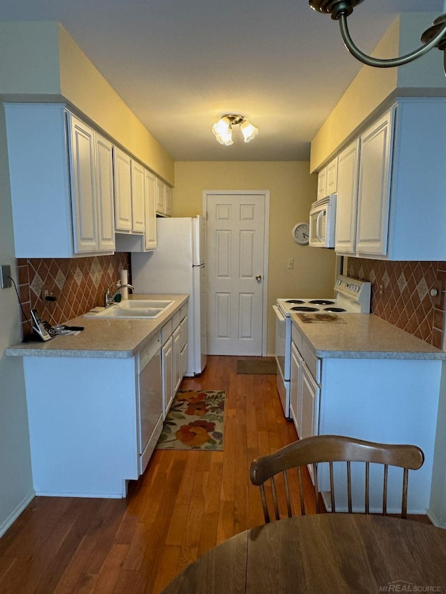 kitchen featuring sink, white cabinetry, tasteful backsplash, dark hardwood / wood-style floors, and white appliances