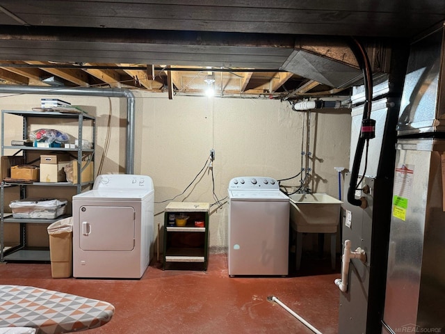 laundry area with separate washer and dryer and sink