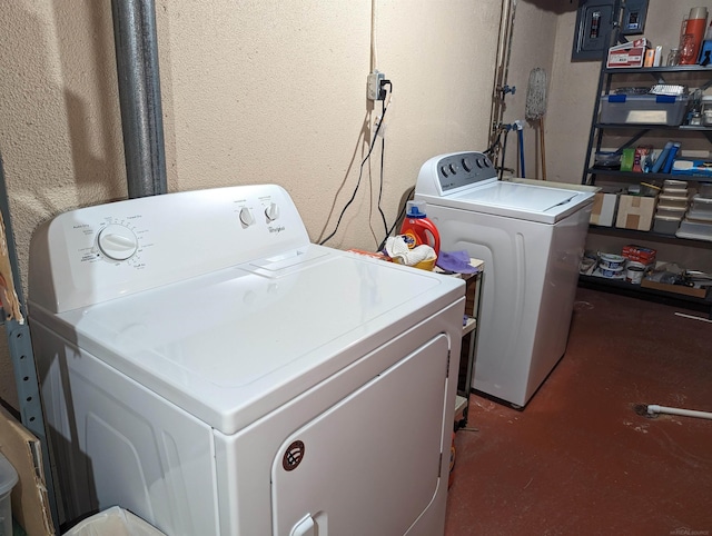 clothes washing area with separate washer and dryer and electric panel