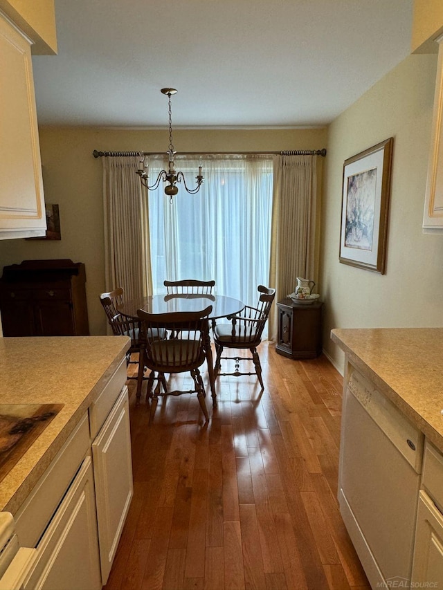 dining space featuring hardwood / wood-style flooring and an inviting chandelier