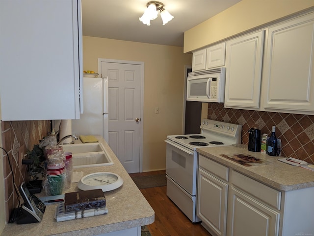 kitchen with tasteful backsplash, white appliances, dark hardwood / wood-style flooring, and white cabinets