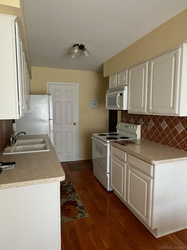 kitchen featuring backsplash, white appliances, sink, and white cabinets