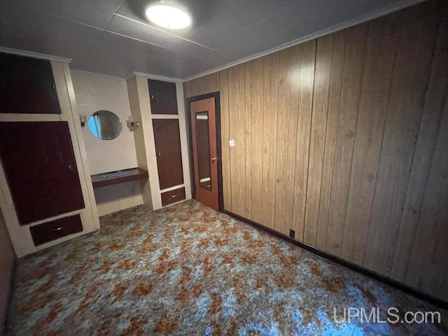 spare room with crown molding and wooden walls