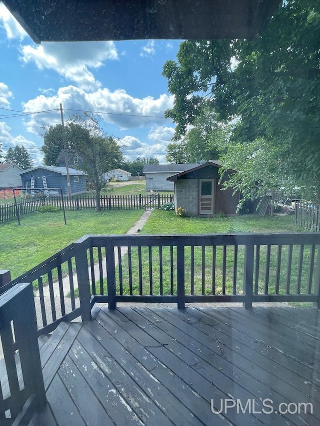 deck with a lawn and an outdoor structure