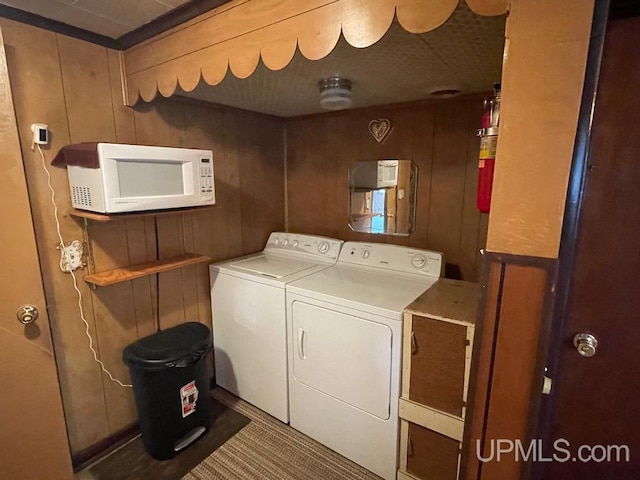 laundry room featuring separate washer and dryer and wooden walls