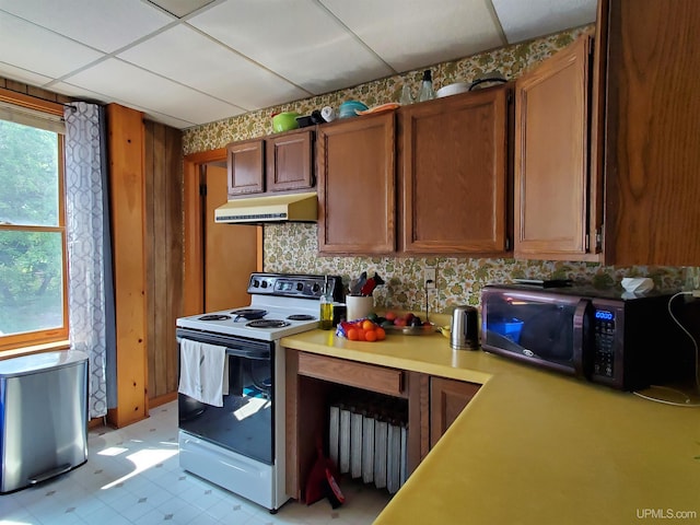 kitchen featuring white electric range oven, a paneled ceiling, light countertops, black microwave, and under cabinet range hood