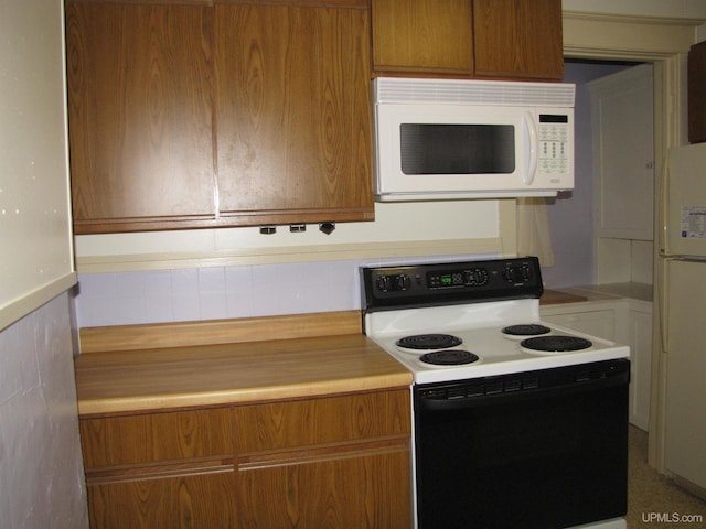 kitchen with brown cabinets, white appliances, and light countertops