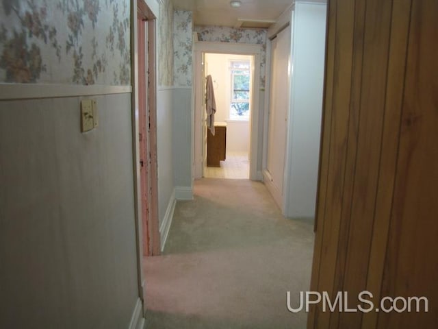 hallway with wainscoting, carpet, and wallpapered walls