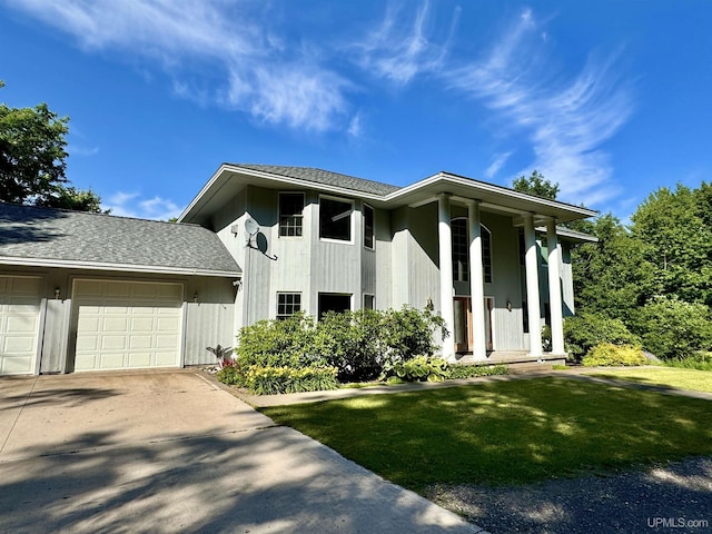 view of front of house with driveway, a front yard, a garage, and a shingled roof