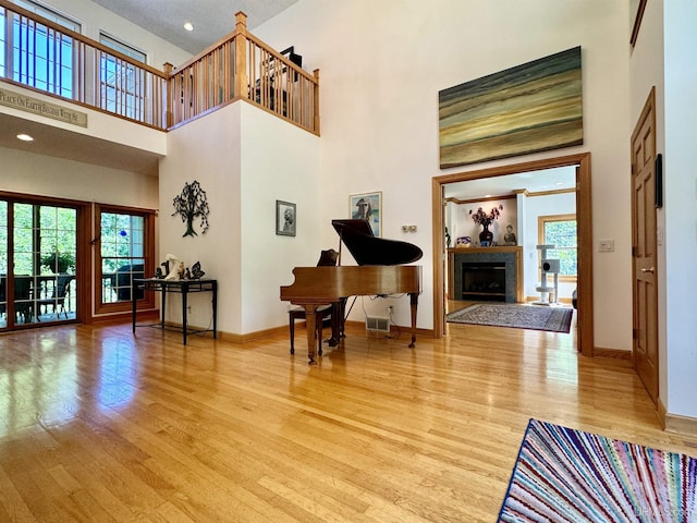 foyer entrance featuring light wood finished floors, a healthy amount of sunlight, and a fireplace