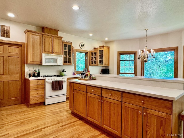 kitchen featuring brown cabinetry, white appliances, light countertops, and light wood-type flooring