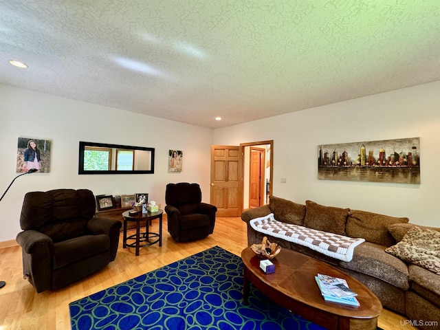 living area featuring recessed lighting, a textured ceiling, and wood finished floors