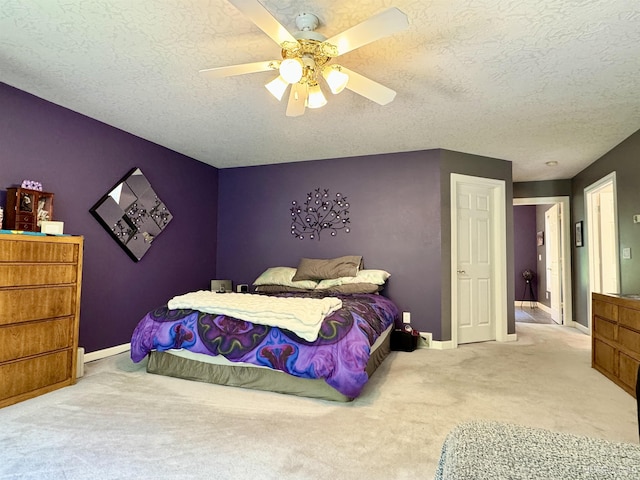 bedroom with baseboards, a ceiling fan, carpet flooring, and a textured ceiling