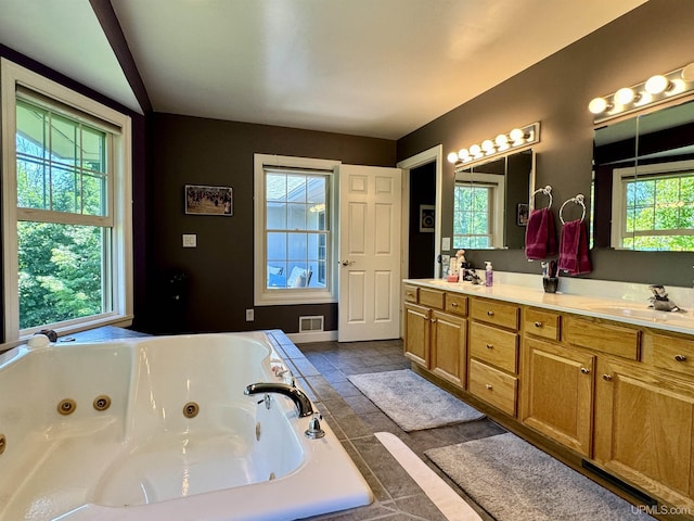 full bathroom featuring double vanity, a whirlpool tub, visible vents, and a sink