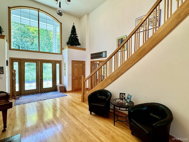 entrance foyer featuring baseboards, stairs, a high ceiling, and wood finished floors