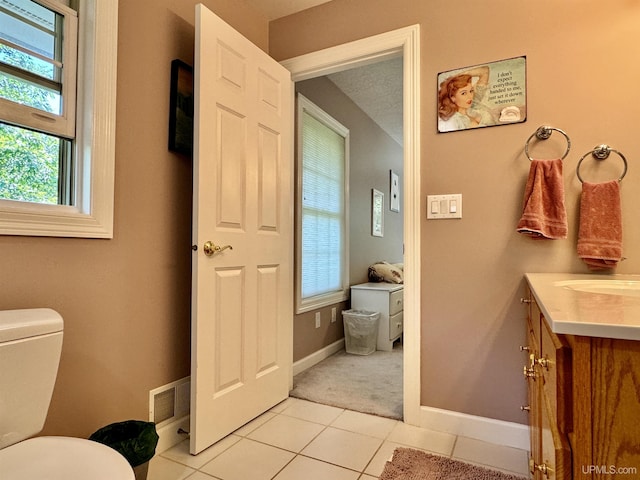 bathroom with visible vents, toilet, vanity, and tile patterned flooring