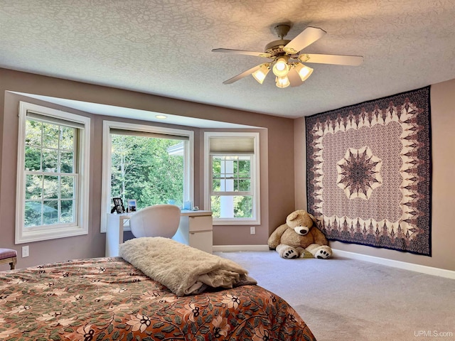 bedroom with baseboards, carpet, a ceiling fan, and a textured ceiling