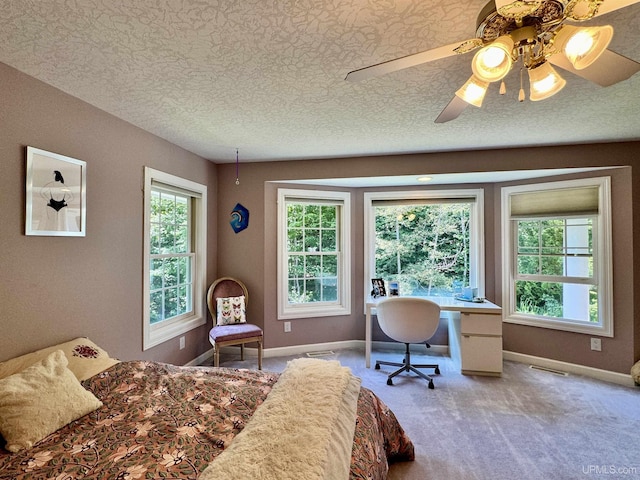 carpeted bedroom featuring baseboards, multiple windows, a textured ceiling, and visible vents