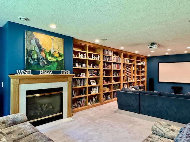 carpeted home theater room featuring a tiled fireplace, recessed lighting, and a textured ceiling