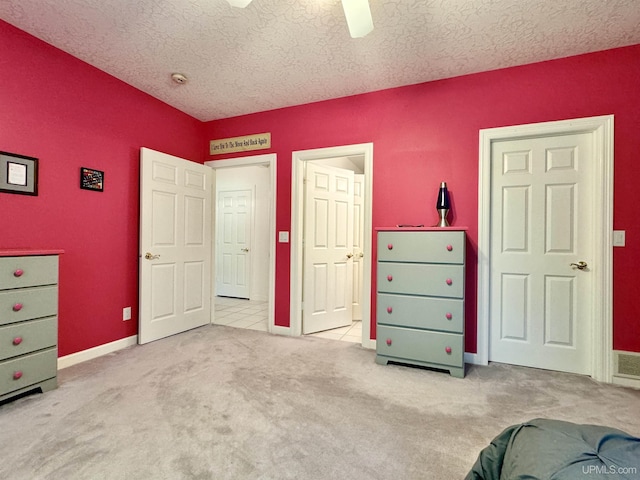 unfurnished bedroom with baseboards, carpet flooring, a textured ceiling, and a ceiling fan