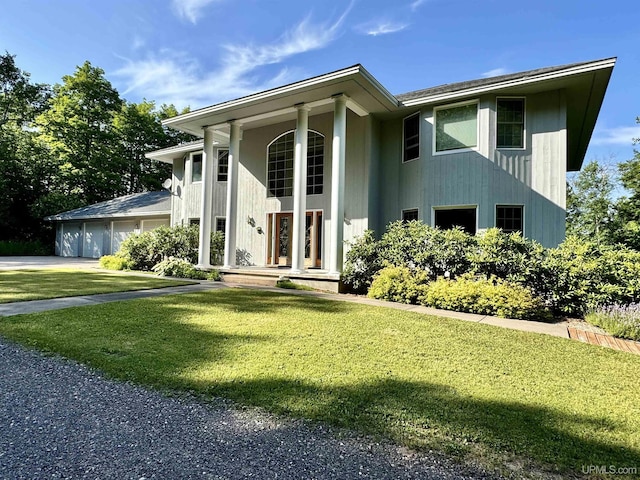 view of front facade with a garage, driveway, and a front lawn