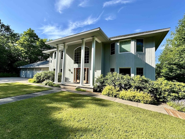 view of front facade with covered porch, a front lawn, and a garage