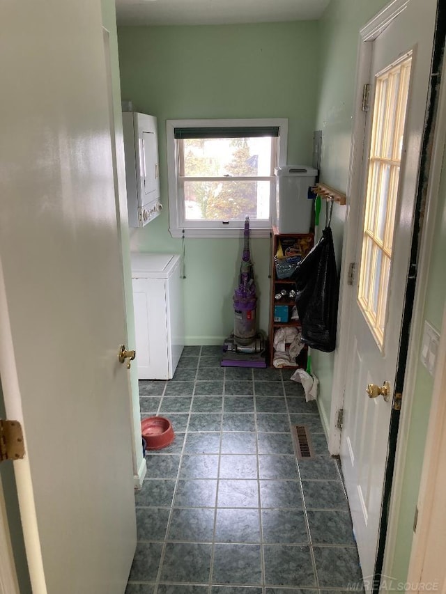 clothes washing area with stacked washer / dryer