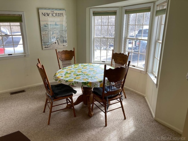 dining area with plenty of natural light and light carpet